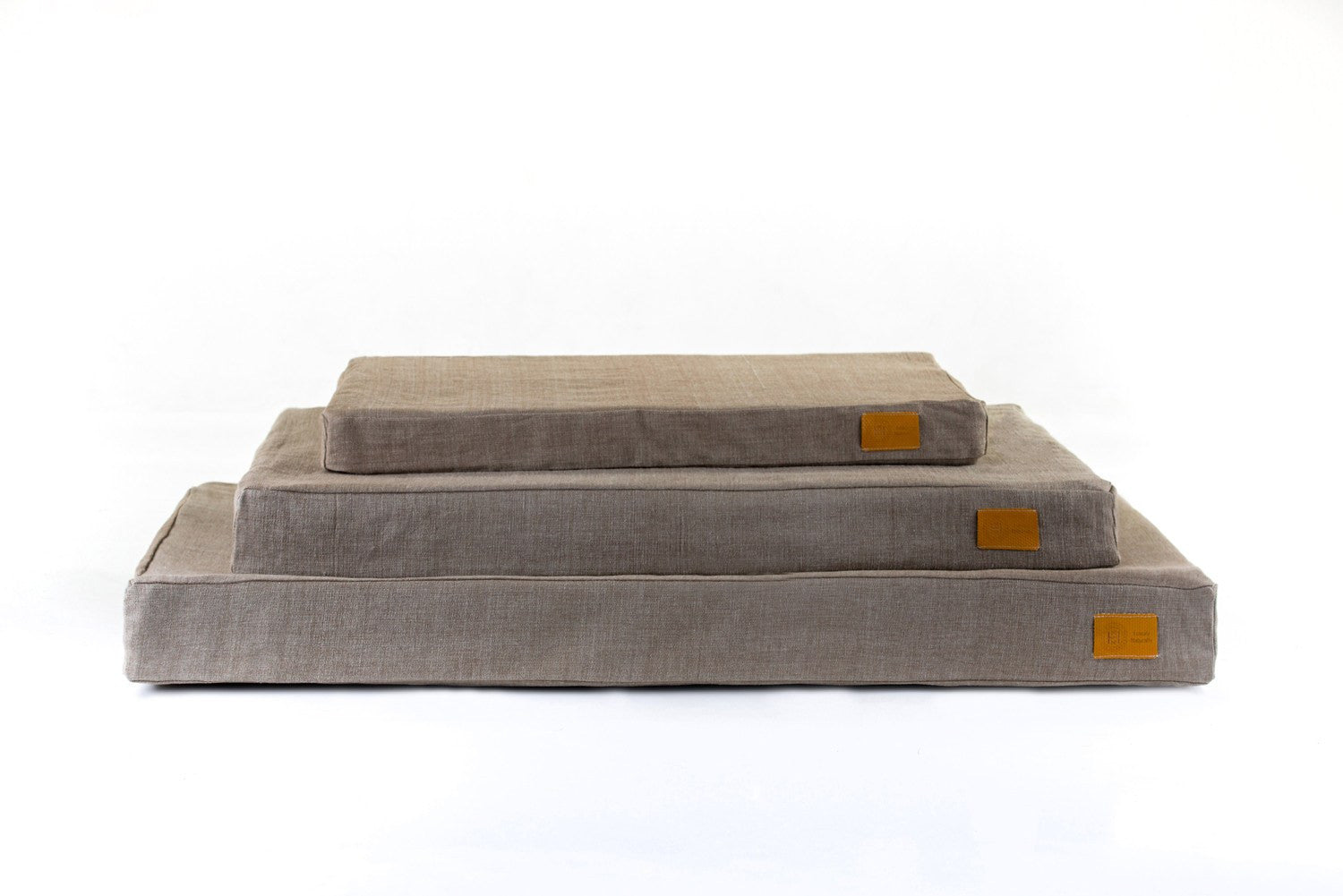 Stack of organic olive cotton Wild Rover natural dog beds. Made from organic materials in Britain.
