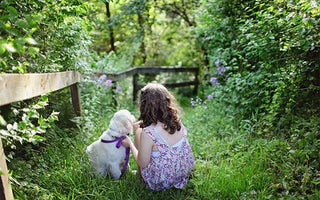 Child sitting with puppy dog. 